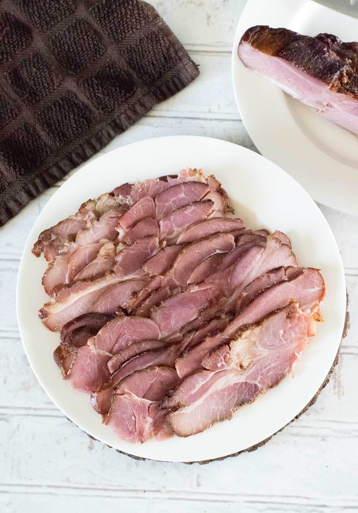 Sliced cottage bacon on a white plate.