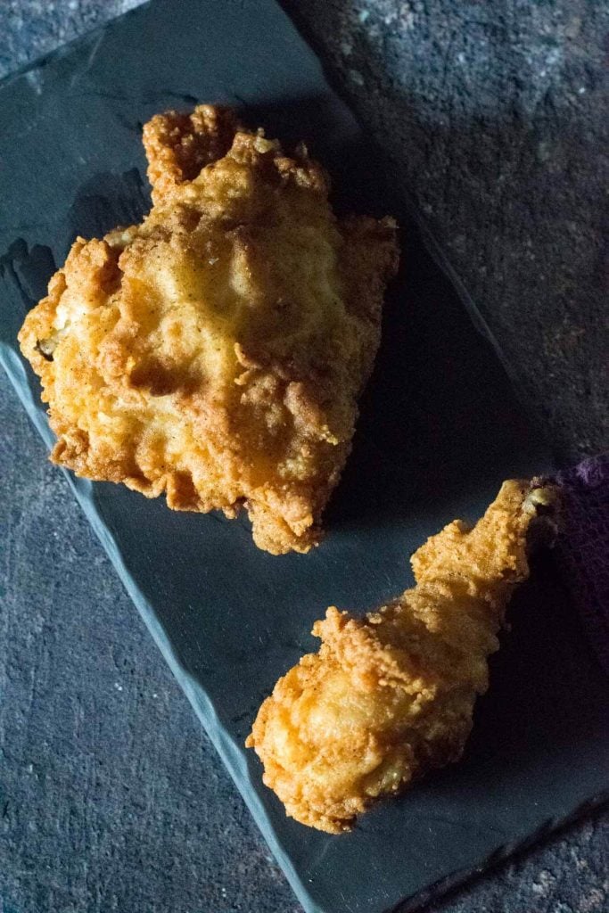 Two pieces of broasted chicken viewed from above.