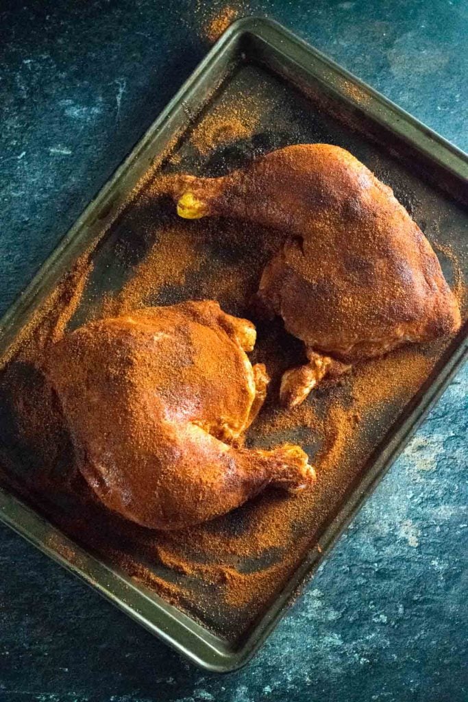 Dry rubbed chicken leg quarters.