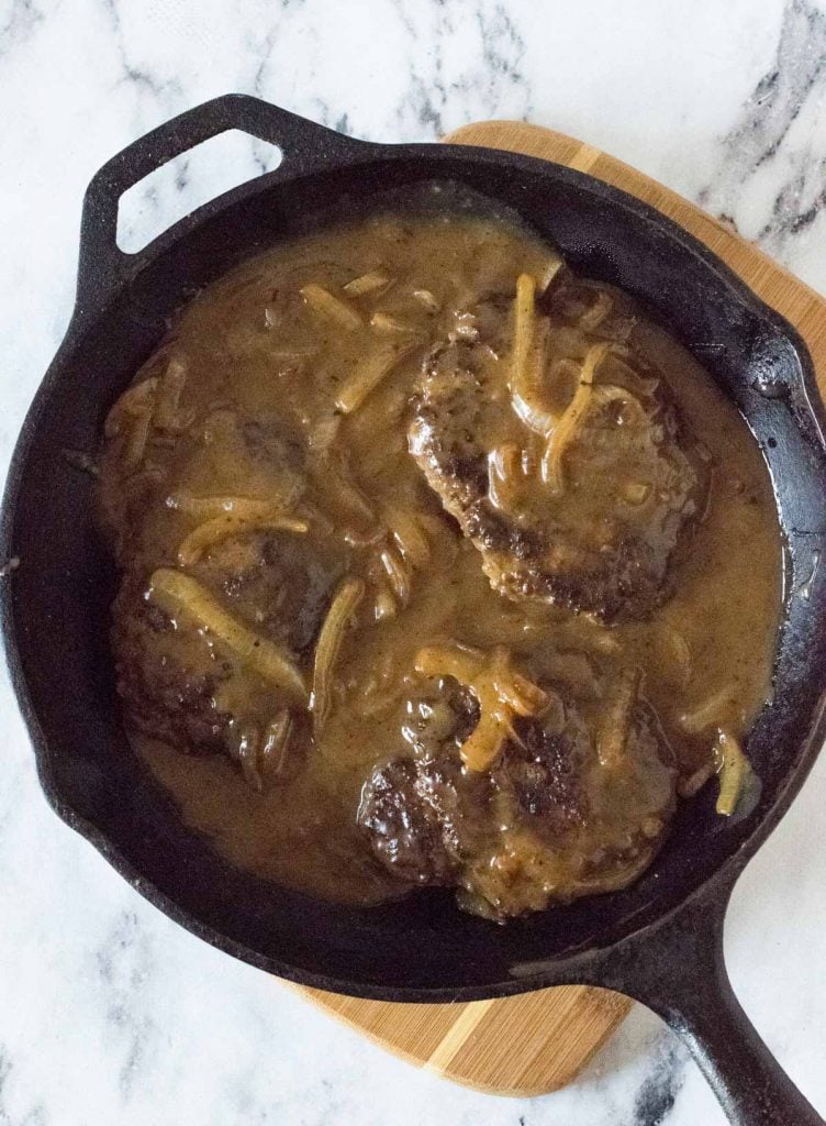 Old fashioned Salisbury steak in black skillet.