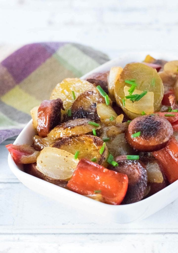 Smothered potatoes and sausage served on table.