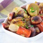 Smothered potatoes and sausage viewed close up.