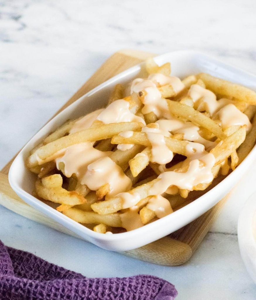 Cheese sauce for fries in white dish.