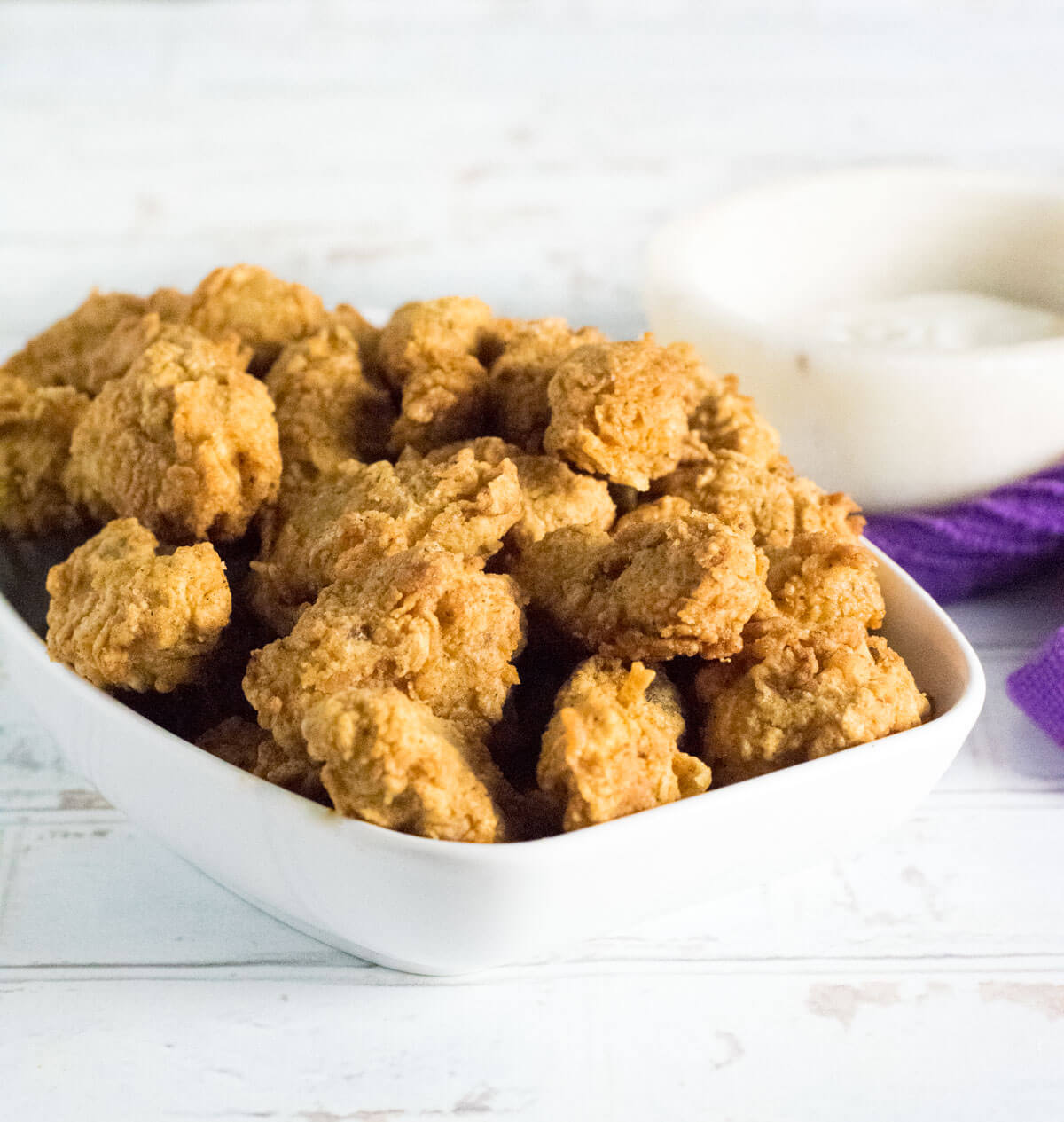 Crispy fried chicken gizzards in a white dish.