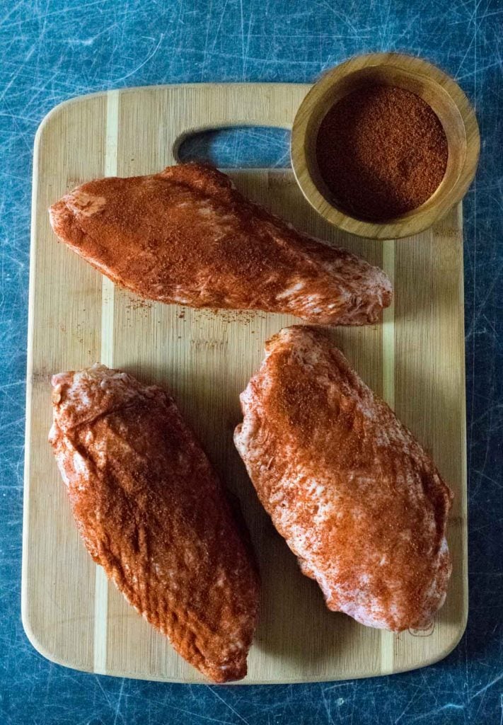 Raw turkey wings dusted with seasoning.