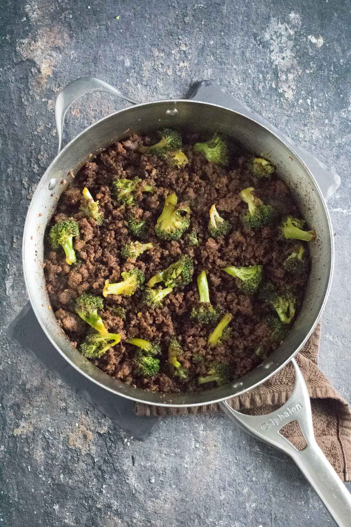 Cooked ground beef and broccoli shown in the skillet.