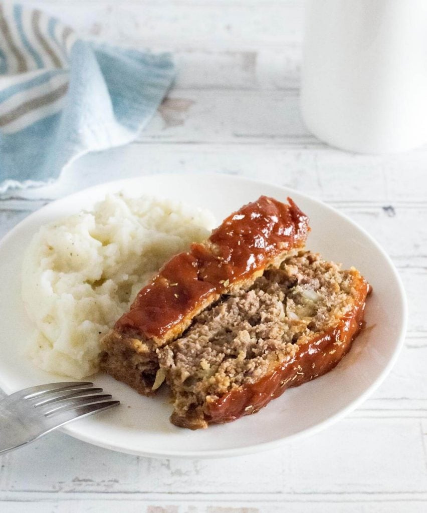 Sliced eggless meatloaf served with mashed potatoes.