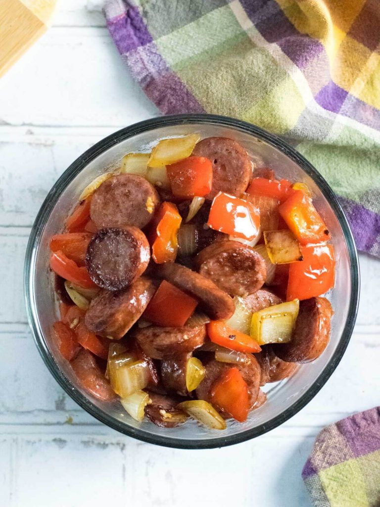 Sauteed sausage, peppers, and onions in bowl.