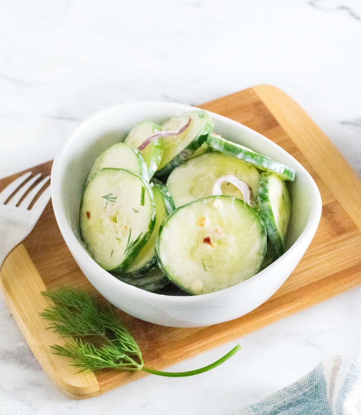Spicy cucumber salad served in bowl.