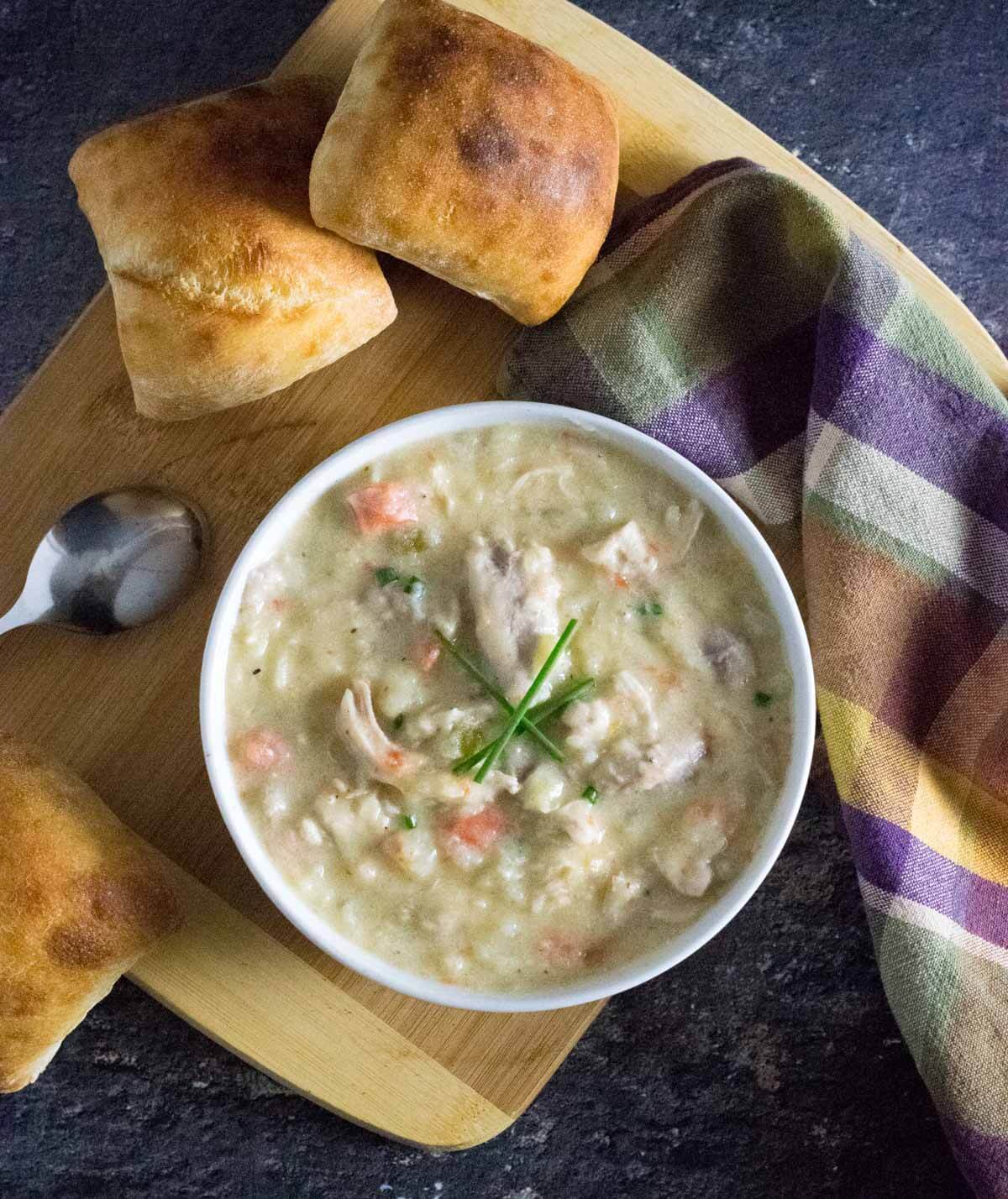 Chicken and potato soup served with fresh bread.