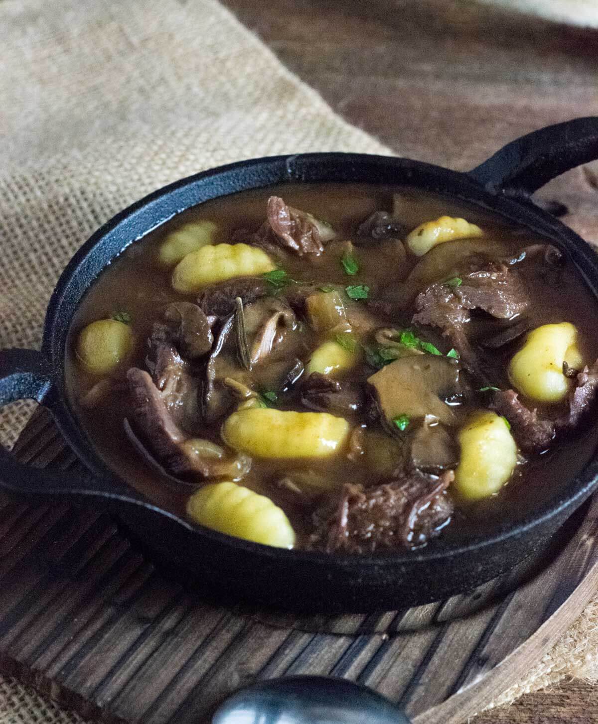 Crock pot venison stew shown in black bowl.