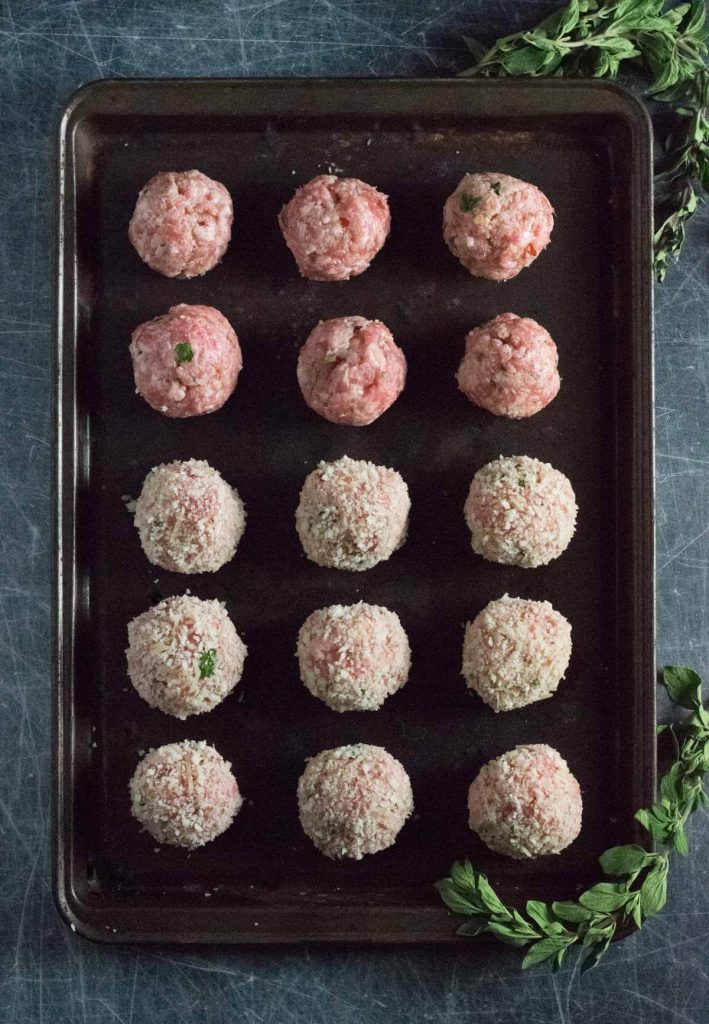 Forming raw meatballs.