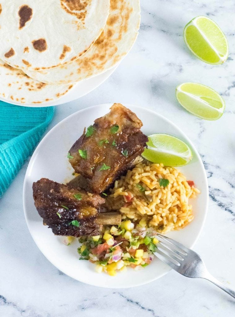 Serving Mexican beef short ribs with sides.