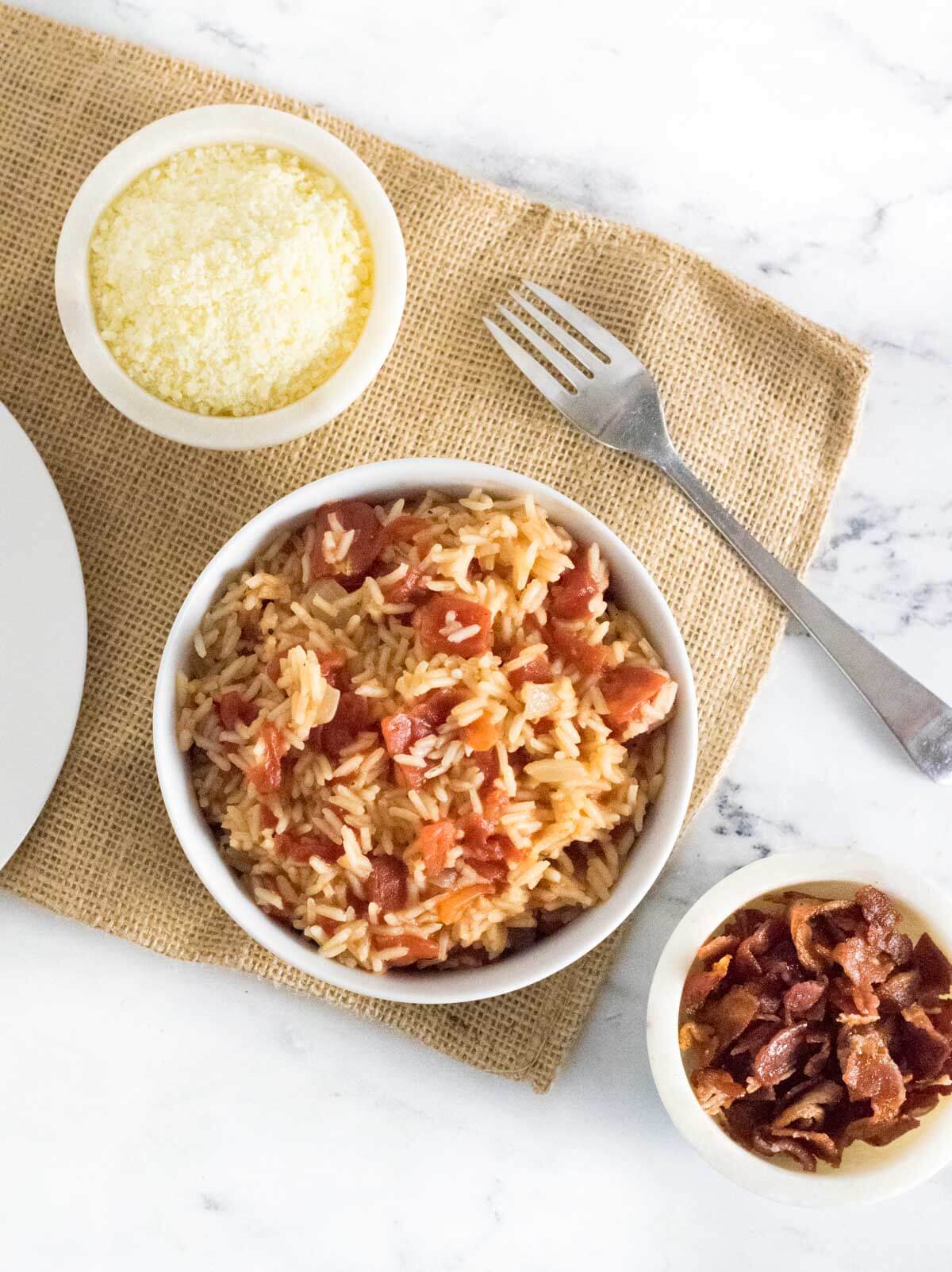 Tomatoes and rice served with bacon and Parmesan cheese.