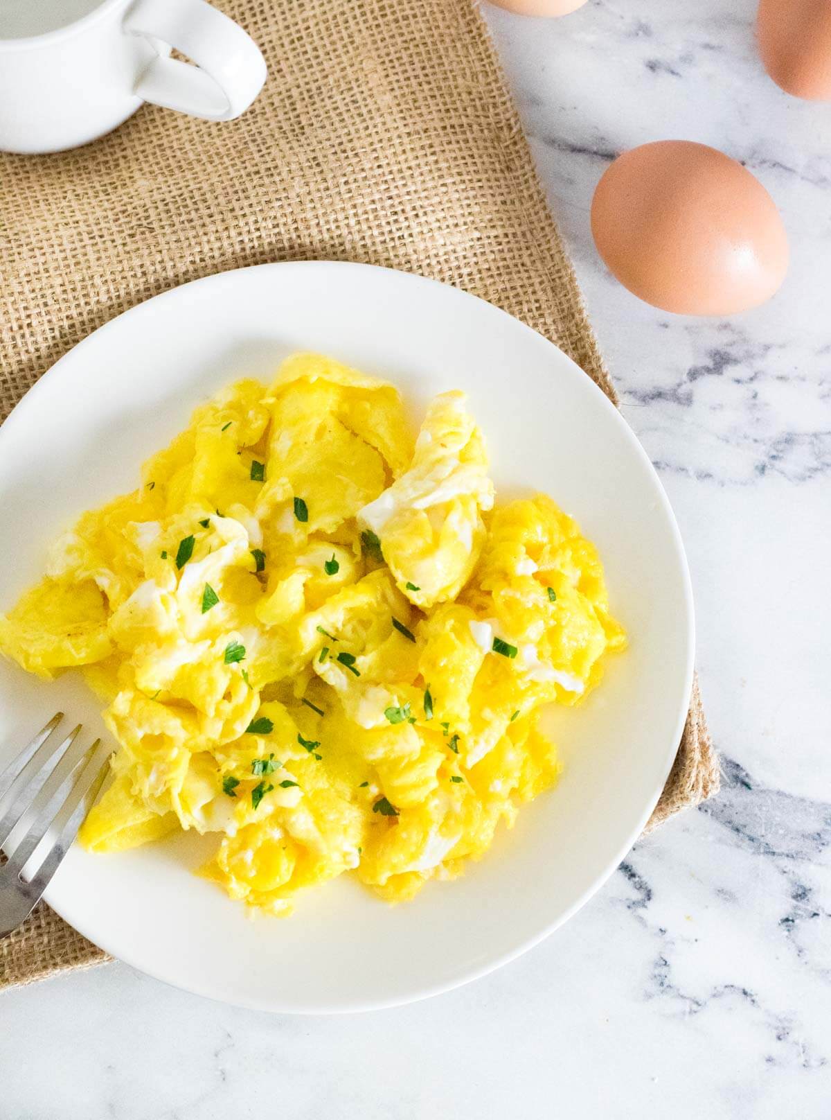 Scrambled eggs with water on a plate.