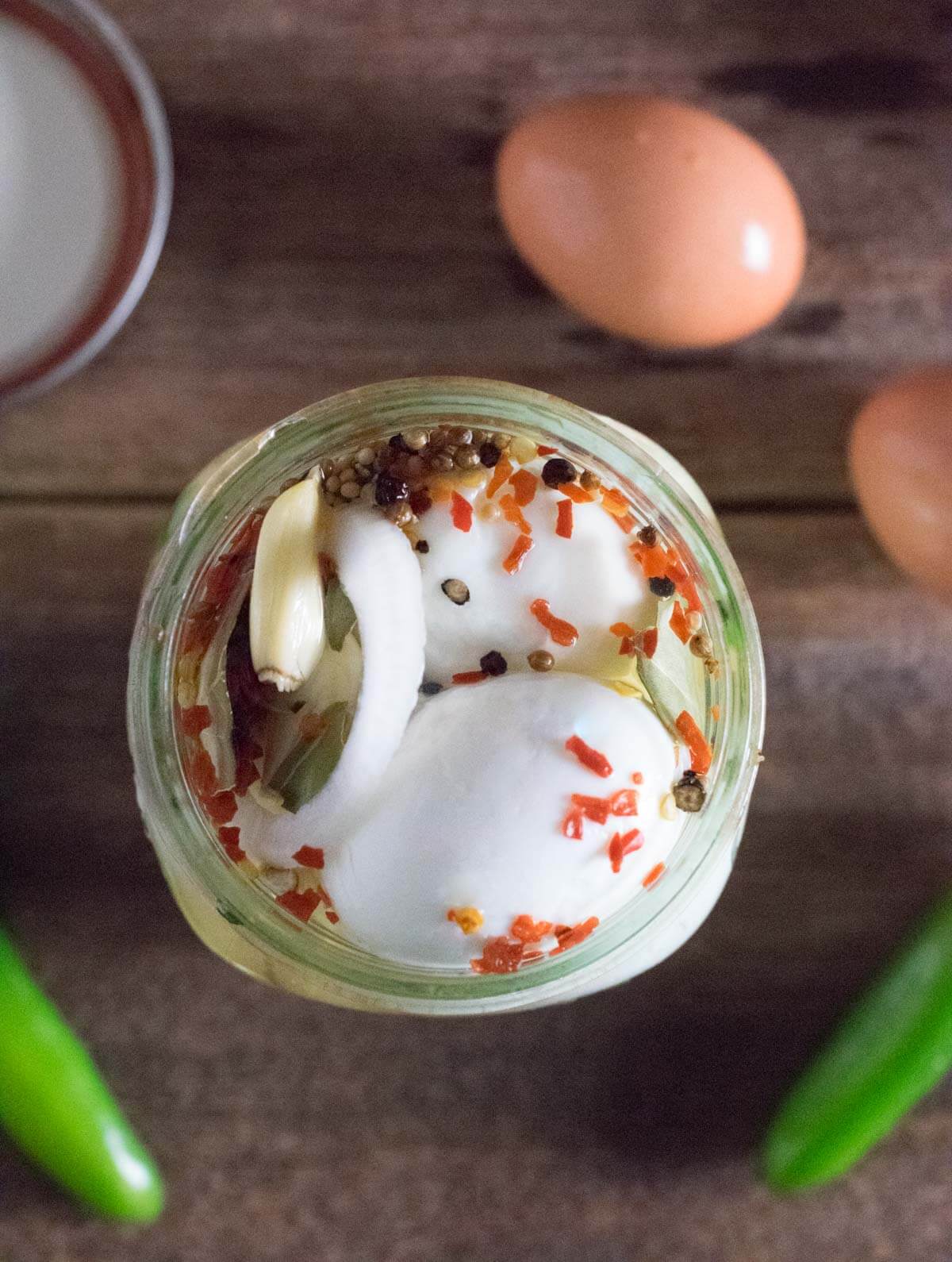 Spicy pickled eggs in jar.