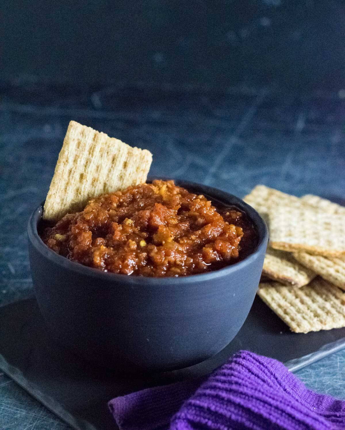 Serving tomato bacon jam with crackers.