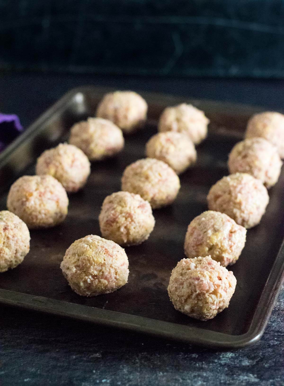 Forming raw sausage balls.