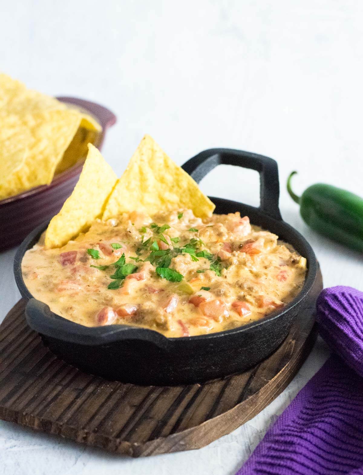 Serving sausage queso dip with tortilla chips.