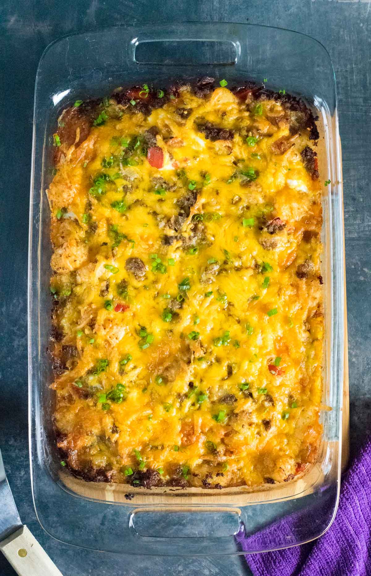 Serving sausage tater tot breakfast casserole.